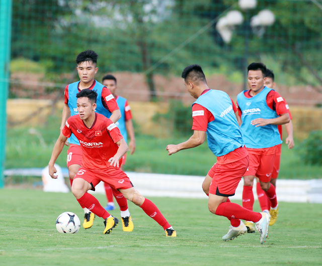 Hai Long (bìa trái) nỗ lực đi bóng trong một buổi tập