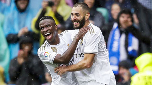 Ở lượt đi, cả Vinicius Jr (trái) và Benzema đều ghi bàn vào lưới Man City